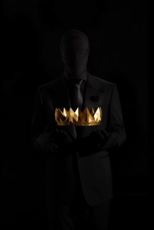 Photo of a man holding a crown of a king